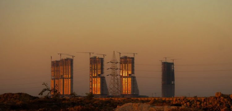 Majestic skyscrapers in El-Alamein glowing under the sunset light, showcasing modern architecture.