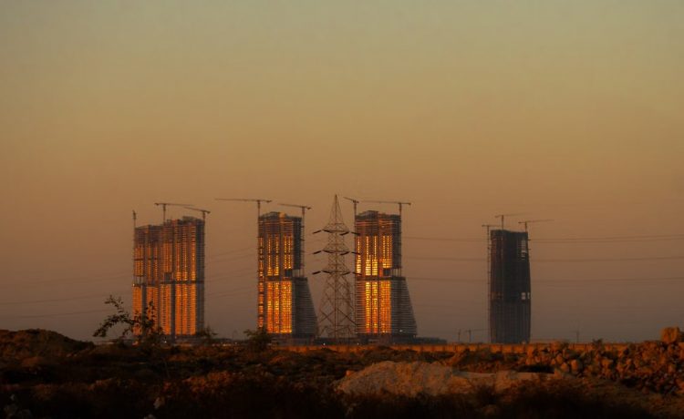 Majestic skyscrapers in El-Alamein glowing under the sunset light, showcasing modern architecture.